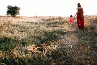Anne ile oğlu yüksek çim yürür