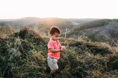 yüksek otların arasında dağlar içinde küçük çocuk