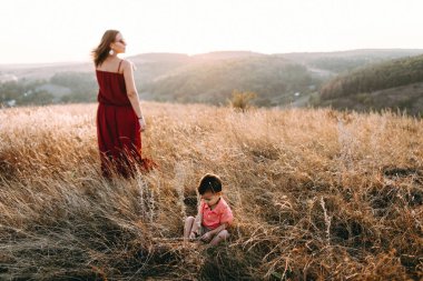 Anne ile oğlu yüksek çim yürür