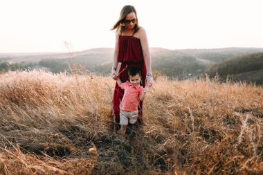 Anne ile oğlu yüksek çim yürür