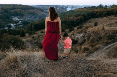 Anne ile oğlu yüksek çim yürür