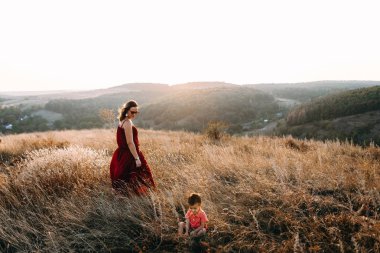 Anne ile oğlu yüksek çim yürür
