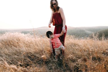 Anne ile oğlu yüksek çim yürür