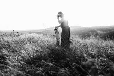 Anne ile oğlu yüksek çim yürür