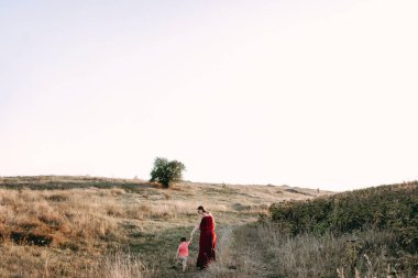 Anne ile oğlu yüksek çim yürür