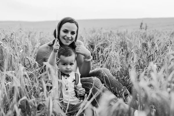 Anne ve oğlu buğday alanında oturmuş — Stok fotoğraf