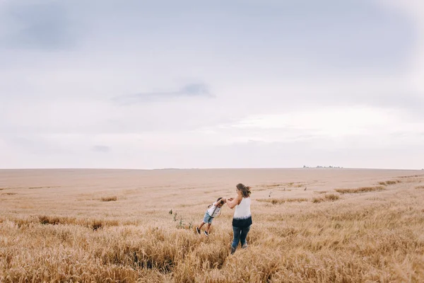 Mother and son walking in wheat field — Stock Photo, Image