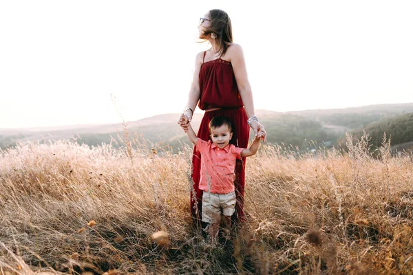 Mãe caminha com filho em grama alta — Fotografia de Stock