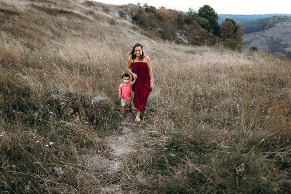 Anne ile oğlu yüksek çim yürür — Stok fotoğraf