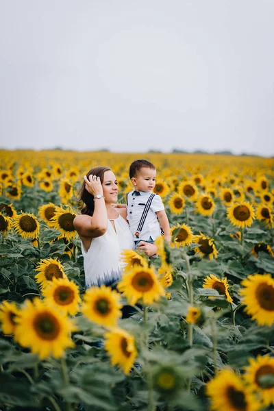 Mère et petit garçon dans un champ de tournesol — Photo