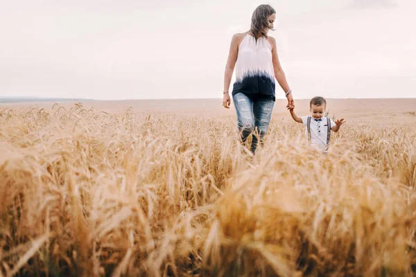 Mother and son walking in wheat field — Stock Photo, Image