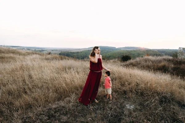 Anne ile oğlu yüksek çim yürür — Stok fotoğraf