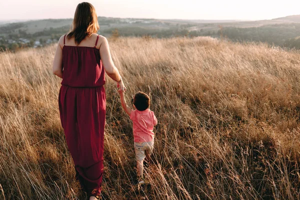 Mother walks with son in high grass — Stock Photo, Image