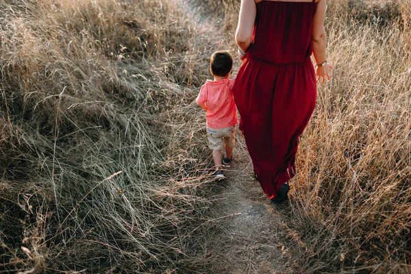 Mère marche avec son fils dans l'herbe haute — Photo