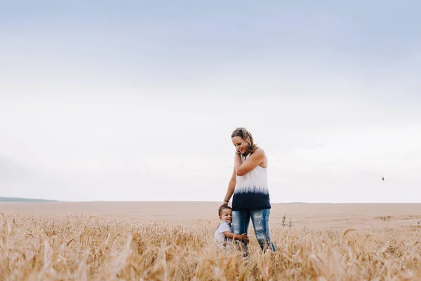 Mother and son walking in wheat field — Stock Photo, Image