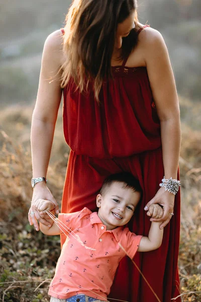 Mamma går med son i högt gräs — Stockfoto