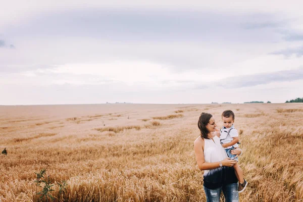 Madre e hijo caminando en el campo de trigo — Foto de Stock