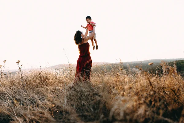 Madre camina con hijo en hierba alta —  Fotos de Stock