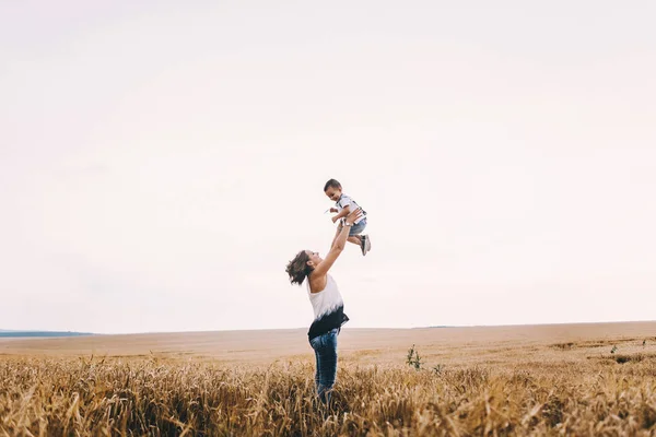 Mother and son walking in wheat field — Stock Photo, Image