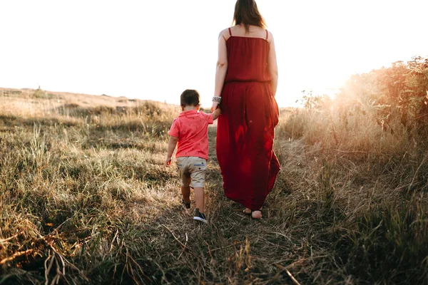 Mother walks with son in high grass — Stock Photo, Image