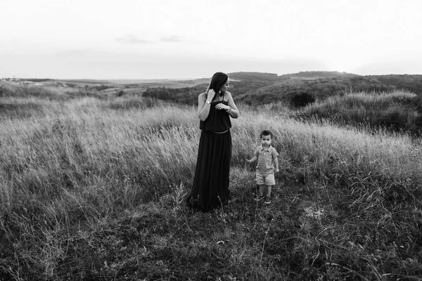 Mutter spaziert mit Sohn im hohen Gras — Stockfoto