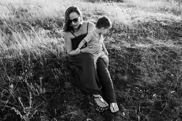 mother walks with son in high grass