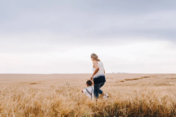 Mother and son walking in wheat field — Stock Photo, Image