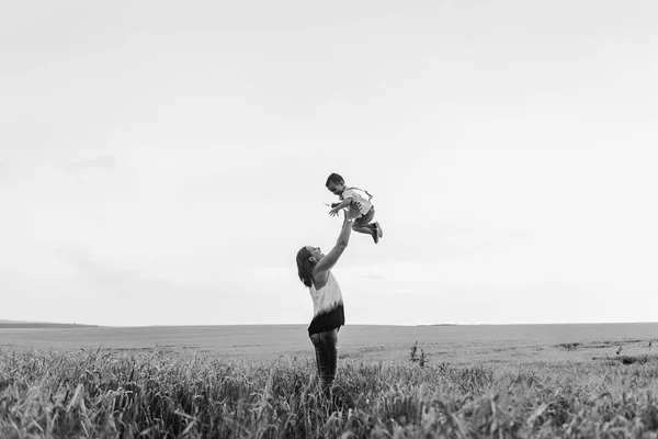 mother and son walking in wheat field