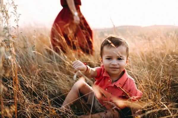 Mãe caminha com filho em grama alta — Fotografia de Stock
