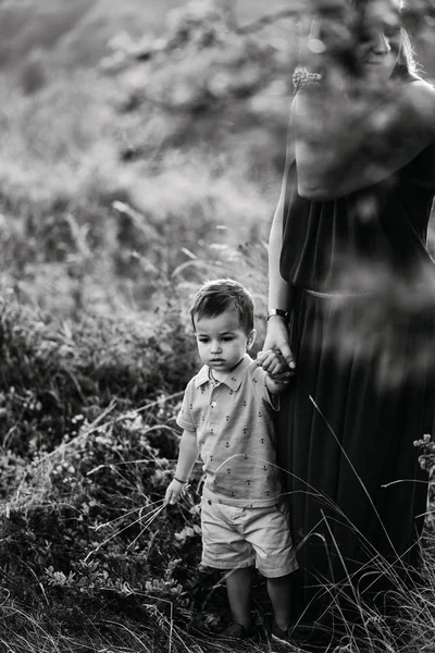 Mãe caminha com filho em grama alta — Fotografia de Stock