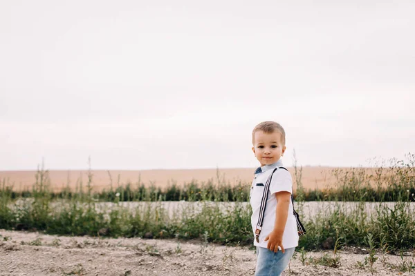 Boy walking in wheat field — Stock Photo, Image