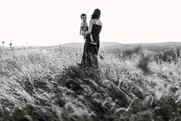 Мати ходить з сином у високій траві — стокове фото