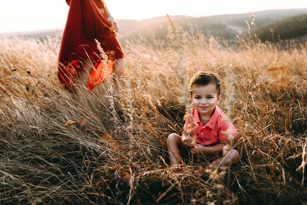 Mère marche avec son fils dans l'herbe haute — Photo