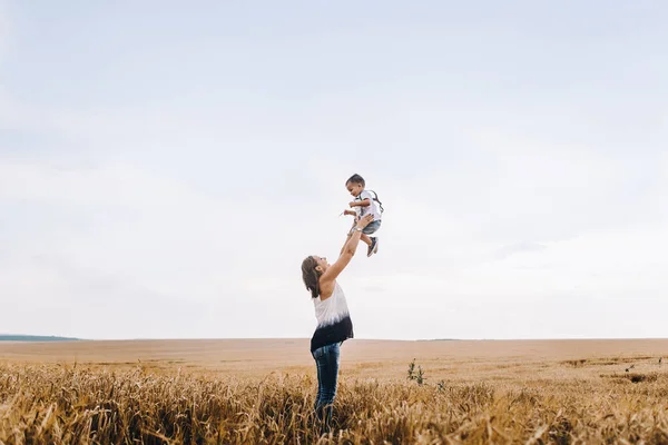 Mother and son walking in wheat field — Stock Photo, Image