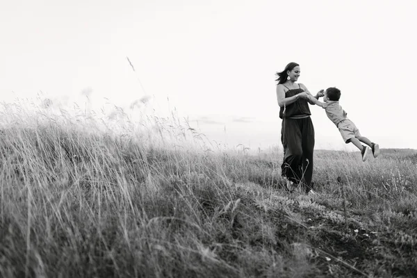Anne ile oğlu yüksek çim yürür — Stok fotoğraf