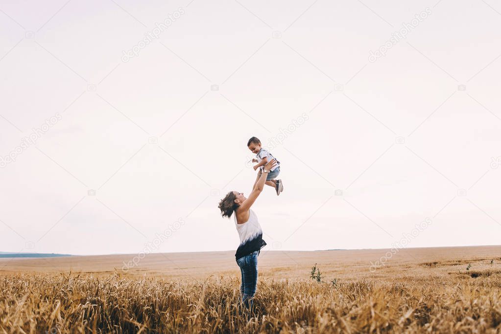 mother and son walking in wheat field