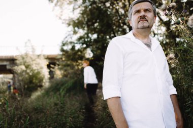 Orta yaşlı çift nehir kenarında yürüyor