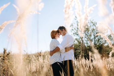 Orta yaşlı çift sarı çim yürür