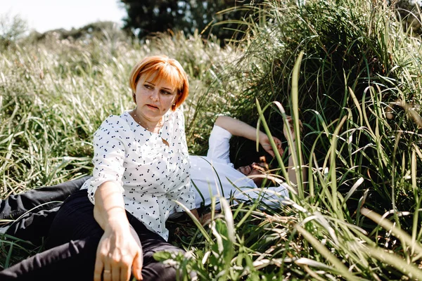 Middle-aged couple resting near the river — Stock Photo, Image