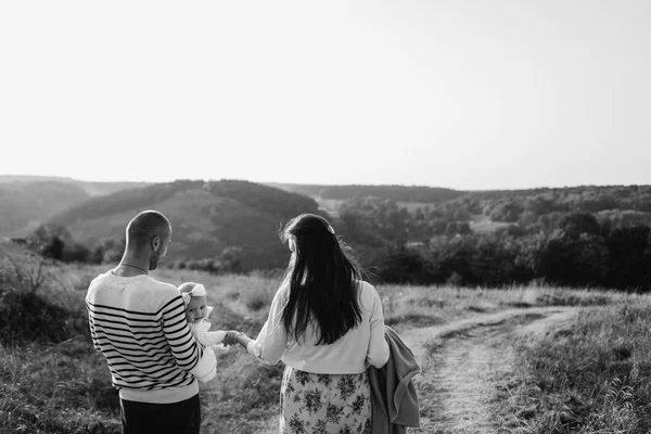 Família jovem com filha andando nas montanhas — Fotografia de Stock