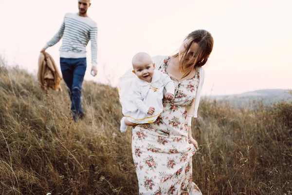 Familia joven con hija caminando en las montañas — Foto de Stock