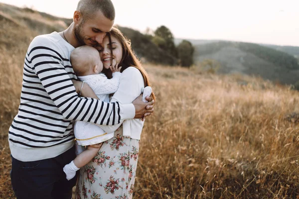 Familia joven con hija caminando en las montañas — Foto de Stock