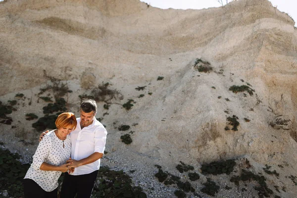 Középkorú pár sétál a sziklák közelében — Stock Fotó