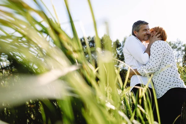 Orta yaşlı çift nehir kenarında yürüyor