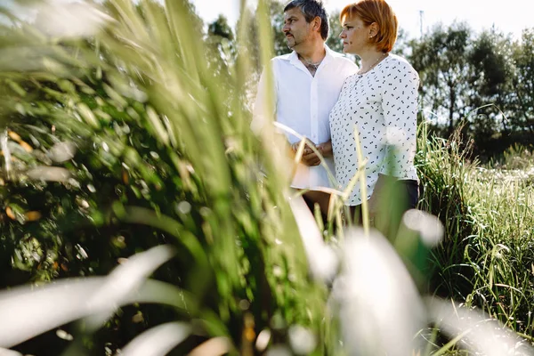 Orta yaşlı çift nehir kenarında yürüyor