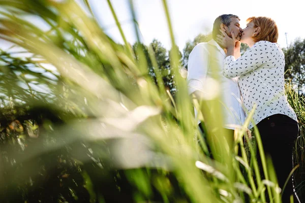 Orta yaşlı çift nehir kenarında yürüyor