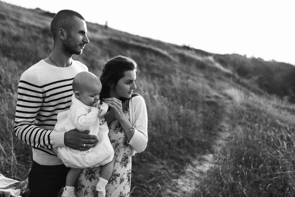 Familia joven con hija caminando en las montañas — Foto de Stock