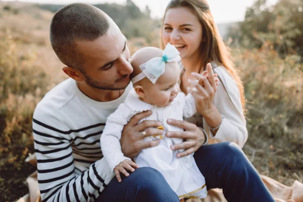 Familia joven con hija caminando en las montañas — Foto de Stock