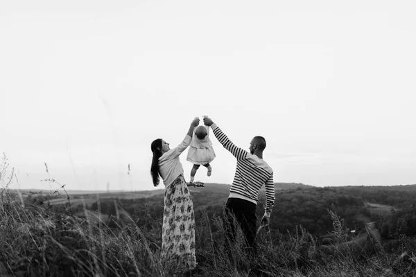 Familia joven con hija caminando en las montañas — Foto de Stock