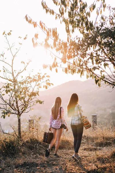 Beautiful girls with bags in mountains — Stock Photo, Image